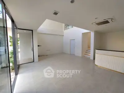 Spacious modern living room with large windows and sleek design, perfect for natural light lovers.