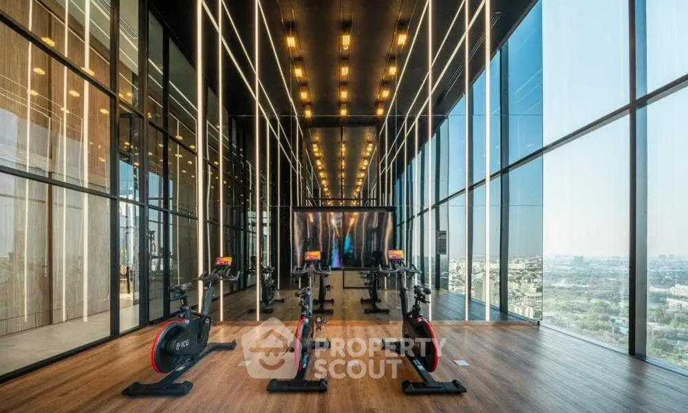 Luxurious high-rise gym with panoramic city views and modern equipment.