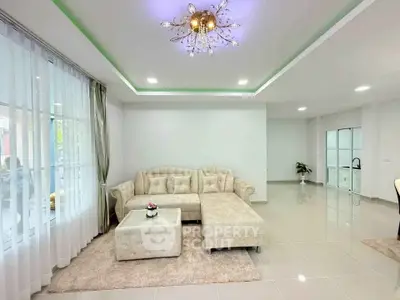 Spacious modern living room with elegant chandelier and plush beige sofa