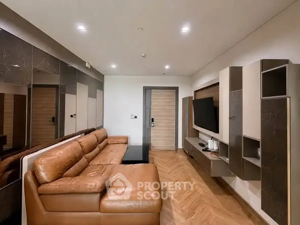Modern living room with leather sofa and wall-mounted TV in stylish apartment.