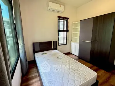 Modern bedroom with large window, air conditioning, and sleek wardrobe in a stylish apartment.