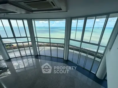 Stunning ocean view from spacious modern living room with floor-to-ceiling windows.