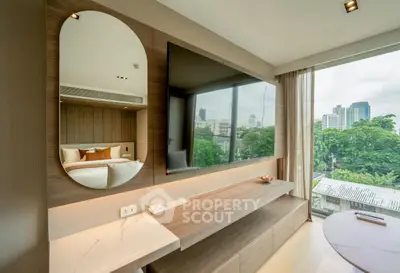 Modern living room with large TV and city view, featuring sleek wooden furniture and elegant decor.
