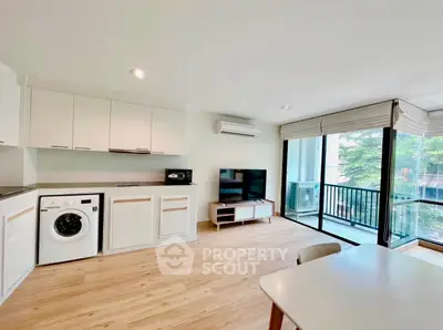 Modern open-plan living room with kitchen and balcony view