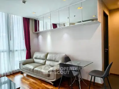 Modern living room with sleek furniture and floor-to-ceiling windows in a stylish apartment.