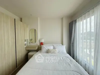 Cozy bedroom with natural light and modern furnishings in a stylish apartment.