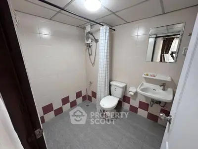 Spacious bathroom with modern fixtures and tiled walls in a real estate property.