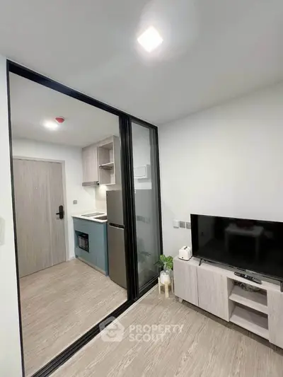 Modern apartment interior with open kitchen and cozy living area, featuring sleek appliances and stylish decor.