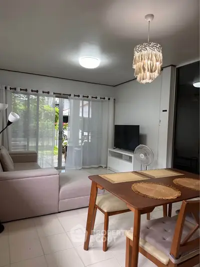 Charming living room with cozy seating, modern decor, and natural light from large windows.