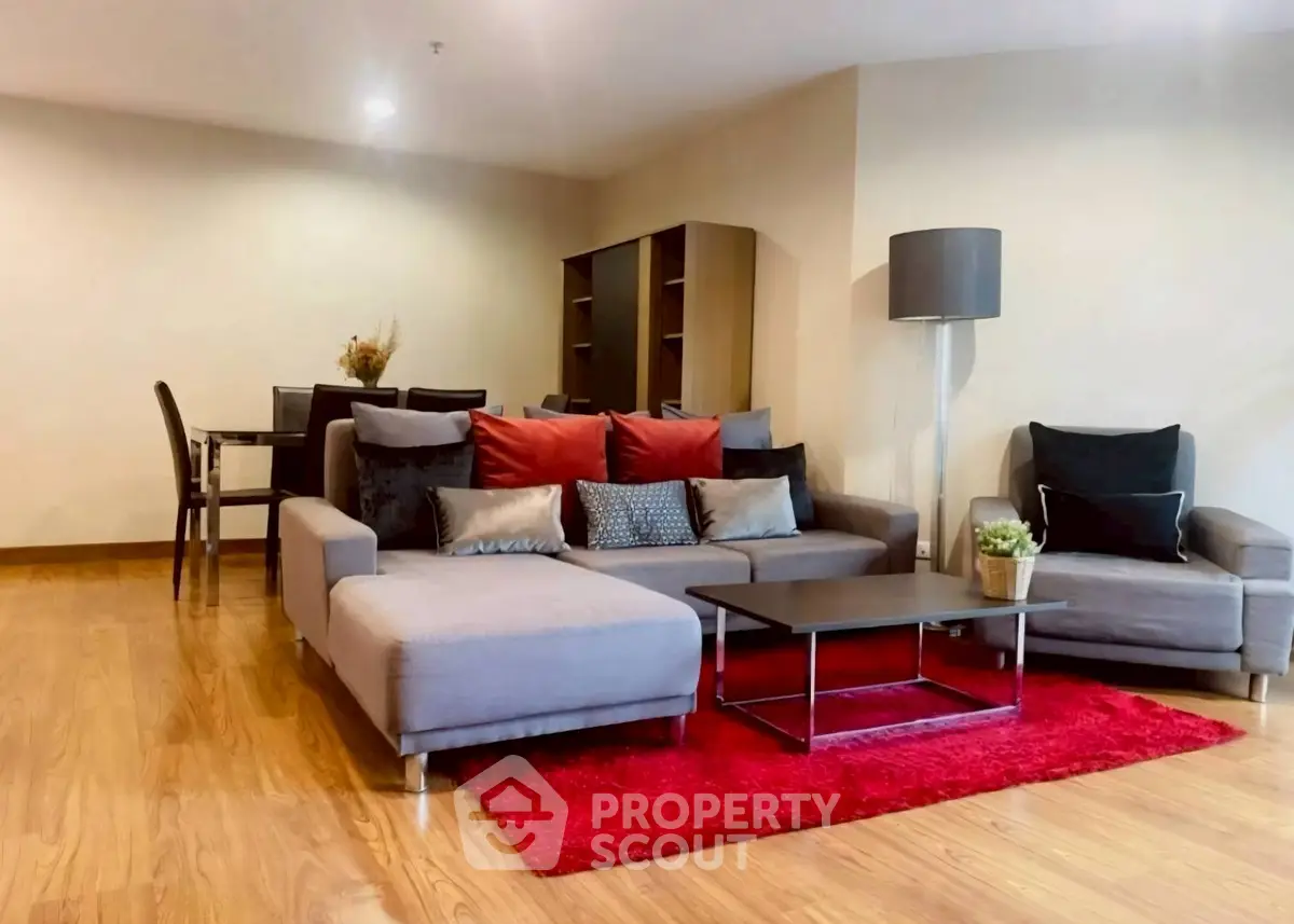 Spacious living room with modern furniture and vibrant red rug