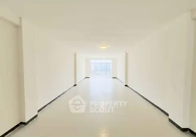 Spacious and bright empty room with large windows and sleek flooring, perfect for customization.