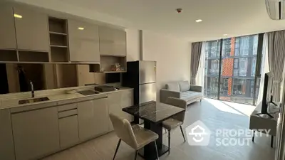 Spacious modern apartment with open layout kitchen, ample natural light, and stylish living area leading to a cozy balcony.