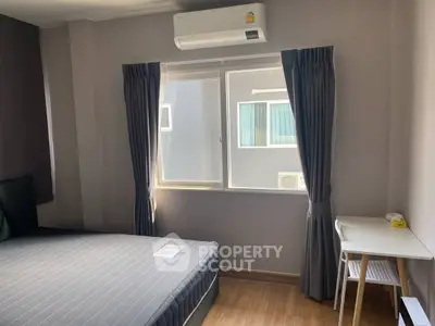 Modern bedroom with natural light, air conditioning, and minimalist decor.