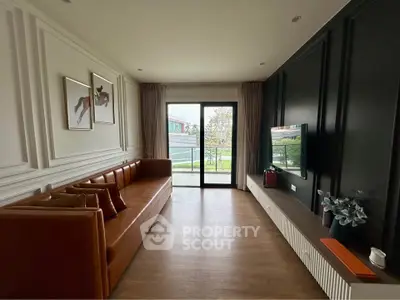 Stylish living room with modern decor and large window offering natural light and garden view.