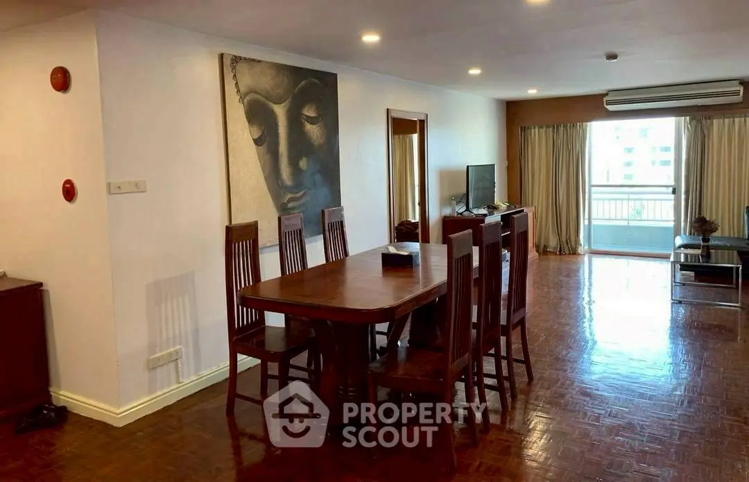 Spacious living room with wooden flooring and elegant dining set, featuring a serene wall art and balcony view.