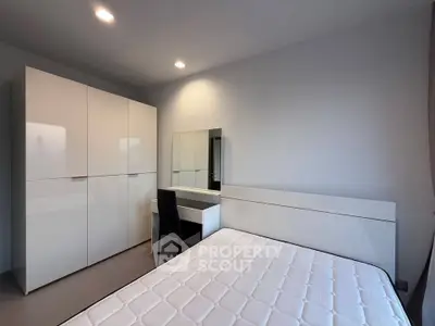 Modern bedroom with sleek white furniture and cozy ambiance