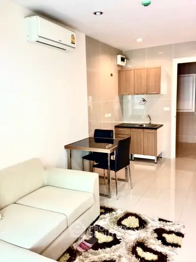 Modern living room with cozy sofa and compact kitchen area