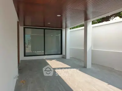 Spacious modern patio with sleek wooden ceiling and large glass doors