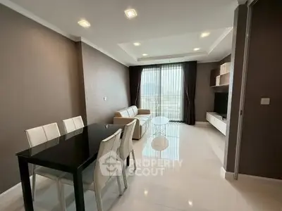Modern living room with dining area and large window offering natural light.
