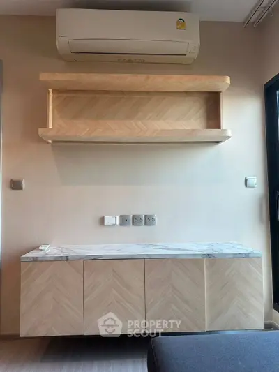 Modern living room with stylish wooden cabinetry and air conditioning unit.