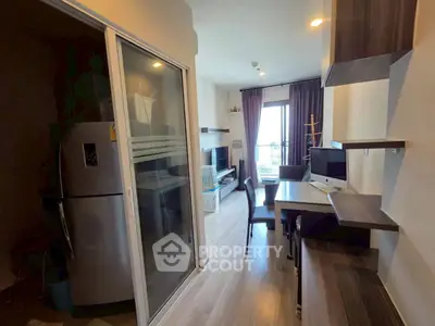 Modern apartment interior with open layout, featuring a sleek kitchen and cozy living area with balcony access.