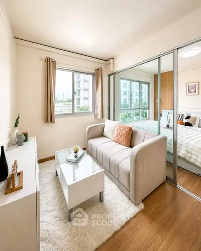 Modern living room with cozy sofa and glass partition leading to bedroom