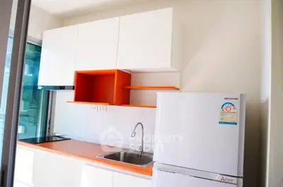 Modern kitchen with sleek cabinets and fridge in a bright apartment