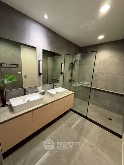 Modern bathroom with dual sinks and glass shower enclosure