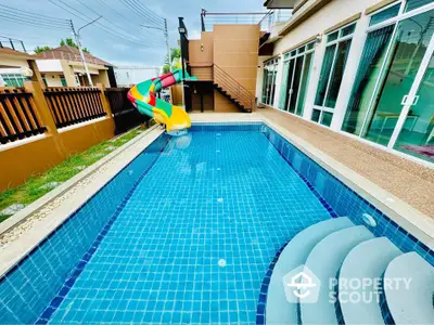 Stunning modern home with private pool and colorful slide, perfect for family fun and relaxation.