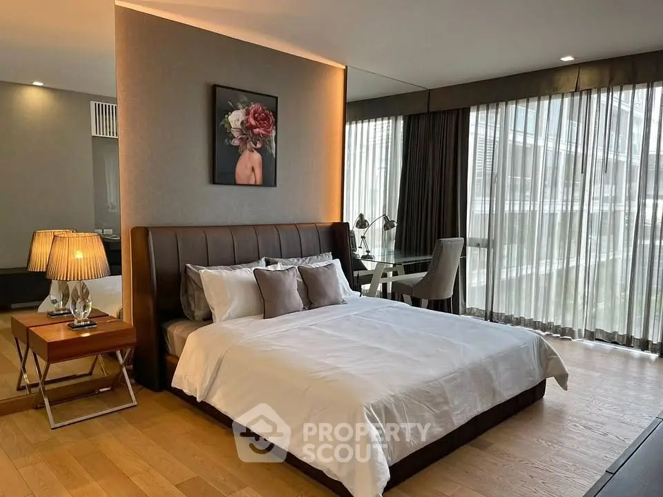 Luxurious bedroom with elegant decor and large windows offering natural light.