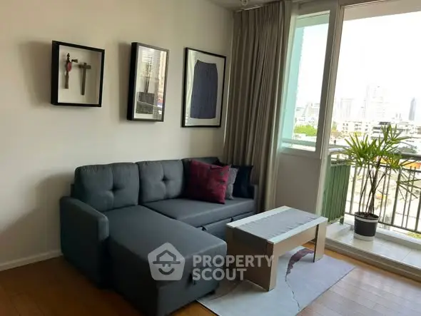 Modern living room with cozy gray sofa, stylish decor, and balcony view.