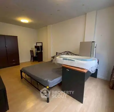 Spacious bedroom with modern furniture and ample natural light, perfect for comfortable living.
