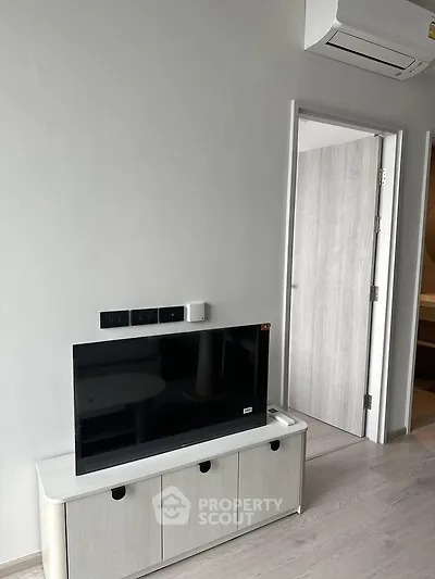 Modern living room with sleek TV setup and air conditioning in a stylish apartment.