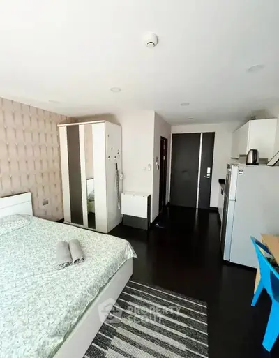 Modern studio apartment with stylish decor and compact kitchen area.