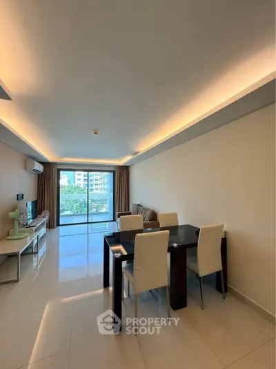 Spacious modern living room with dining area and large windows offering natural light and garden view.