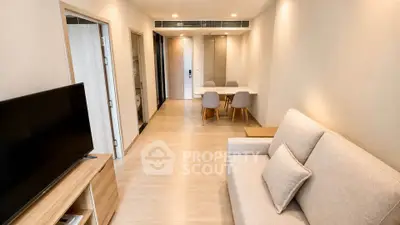 Modern living room with cozy sofa and dining area in open layout apartment.
