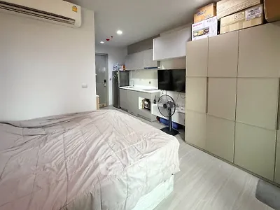 Modern studio apartment with compact kitchen and cozy sleeping area, ideal for urban living.