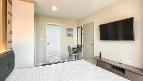 Modern bedroom with wall-mounted TV and minimalist decor