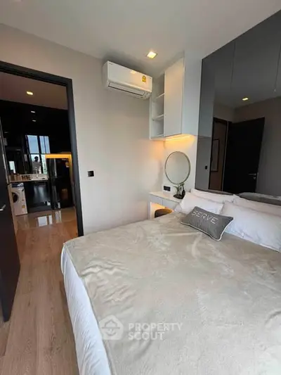 Modern bedroom with cozy bed, air conditioning, and stylish decor in a contemporary apartment.