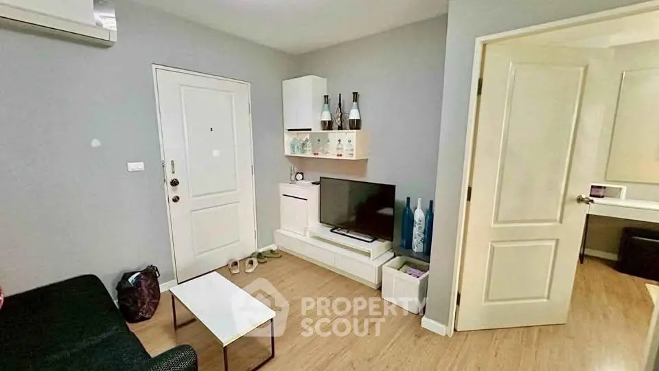 Cozy living room with modern decor and wall-mounted TV in a stylish apartment.