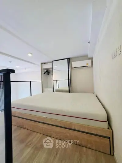 Modern bedroom with sleek design, featuring a comfortable bed and built-in storage, perfect for urban living.