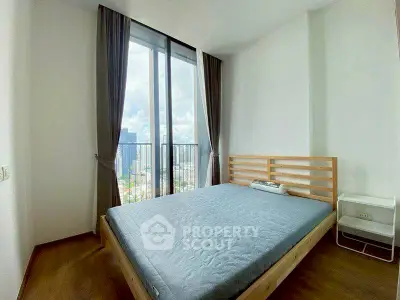 Spacious bedroom with large window offering stunning city views