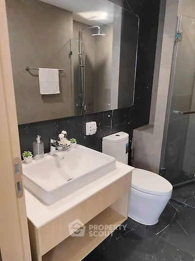 Modern bathroom with sleek fixtures and elegant design, featuring a glass shower and stylish vanity.