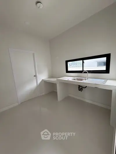 Minimalist kitchen with sleek countertops and modern sink