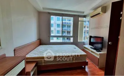 Spacious bedroom with large window and modern furnishings in a high-rise apartment.