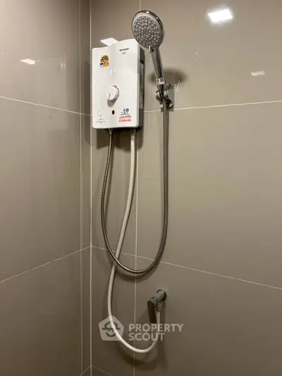 Modern bathroom with sleek shower unit and neutral tiles, perfect for a contemporary home.