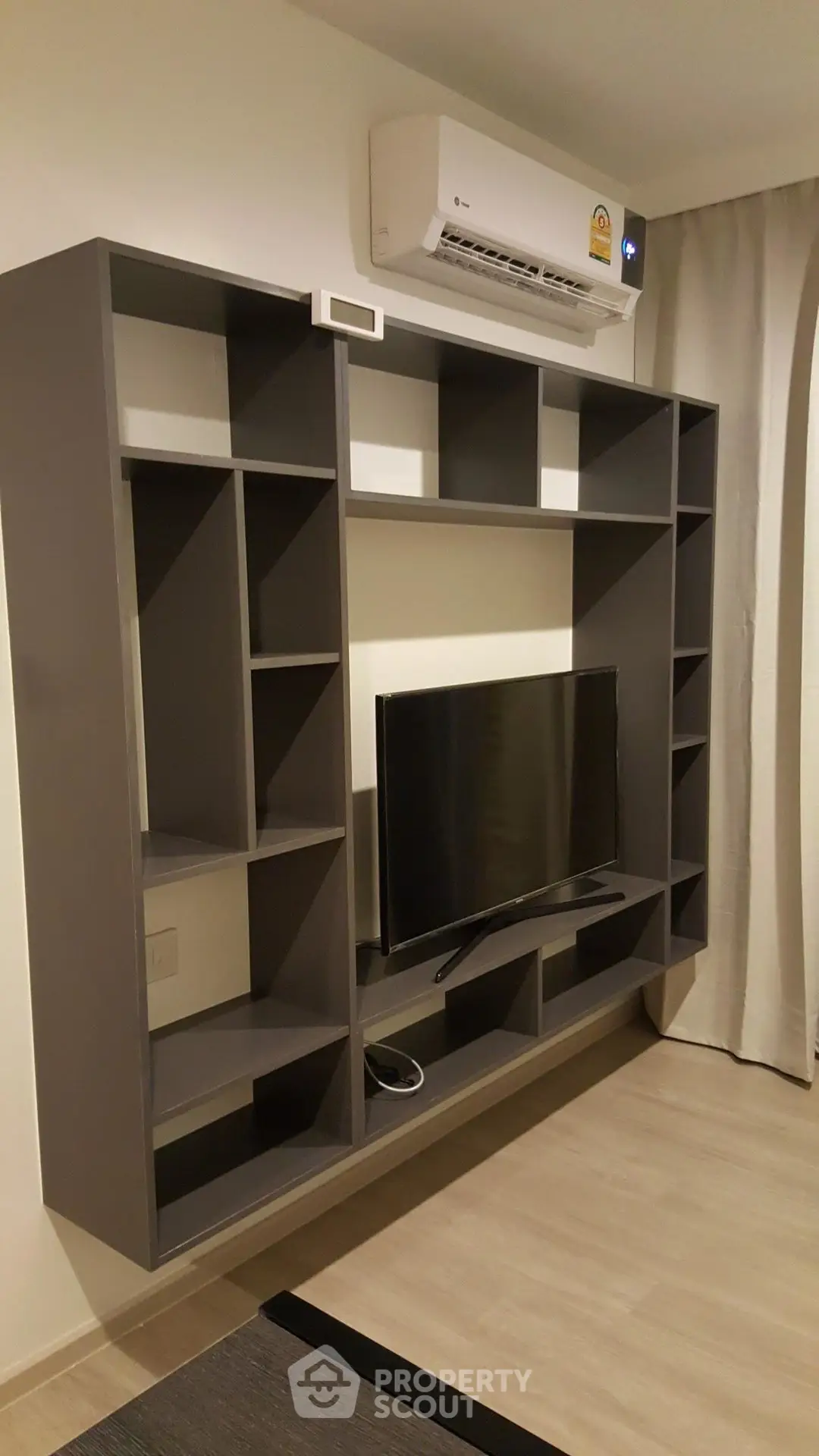 Modern living room with sleek shelving and air conditioning unit