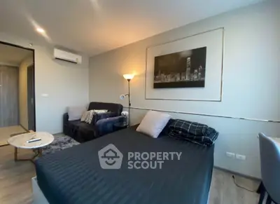 Modern bedroom with stylish decor and cozy seating area in a contemporary apartment.