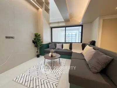Modern living room with stylish sectional sofa and geometric rug