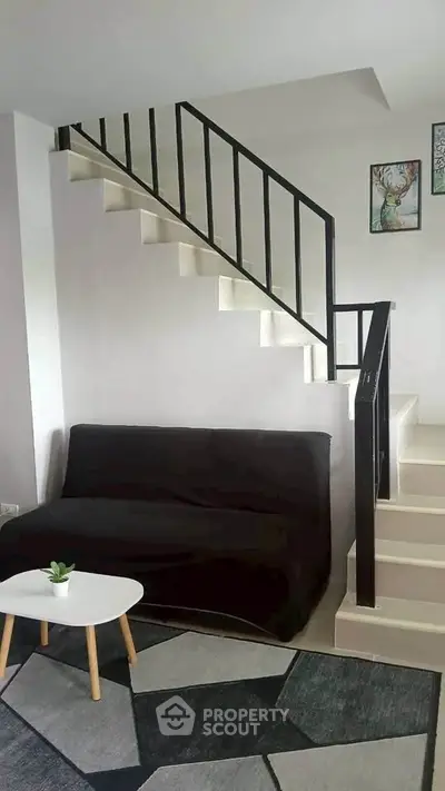Modern living room with stylish staircase and cozy seating area